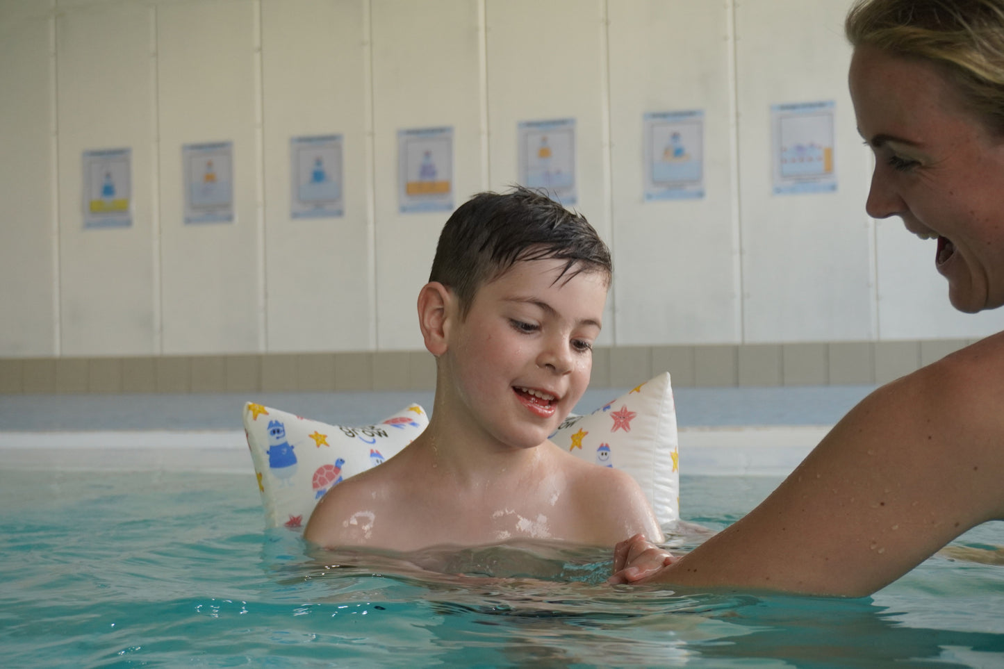 Glücklicher Junge im Pool mit Schwimmkissen